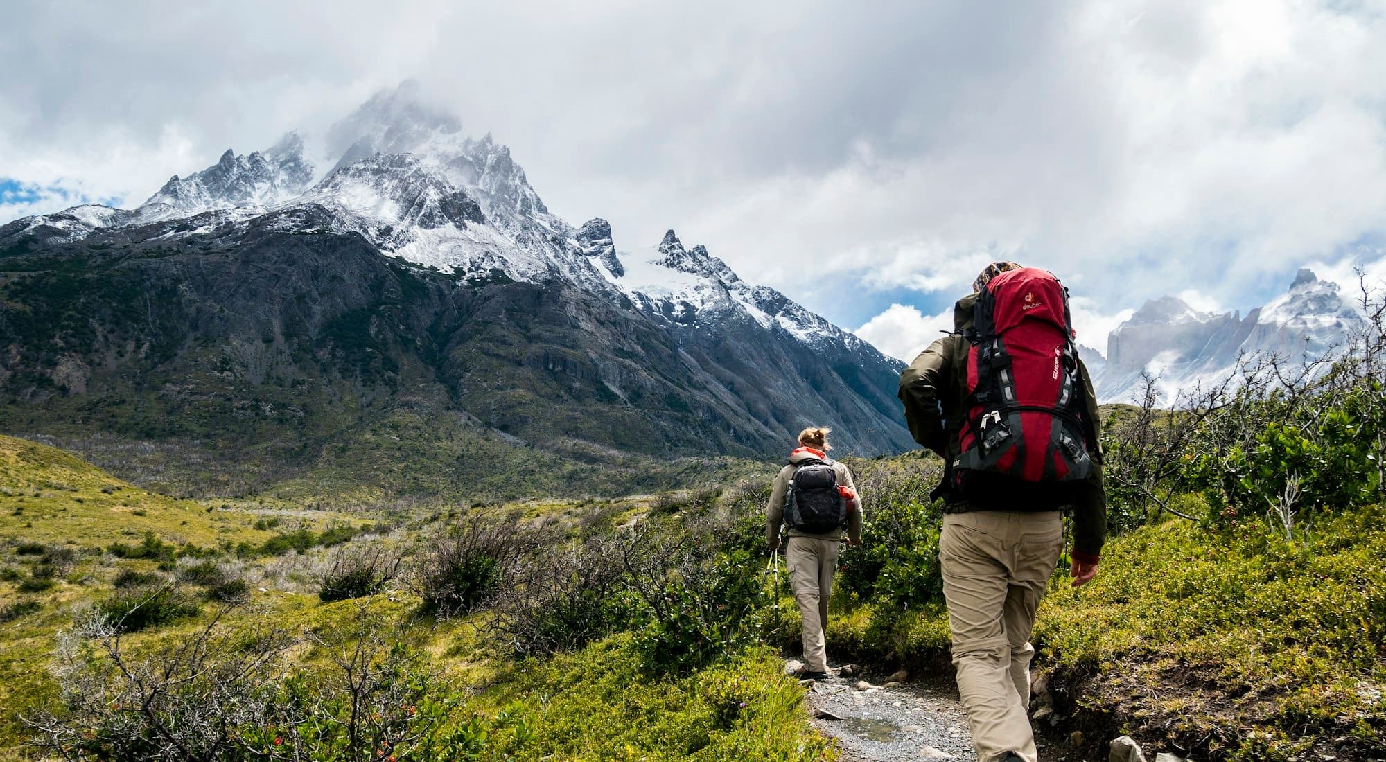 Two people hiking an open mountain trail